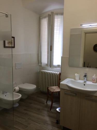 a bathroom with a sink and a toilet and a mirror at Casa Bolego in Cagnò