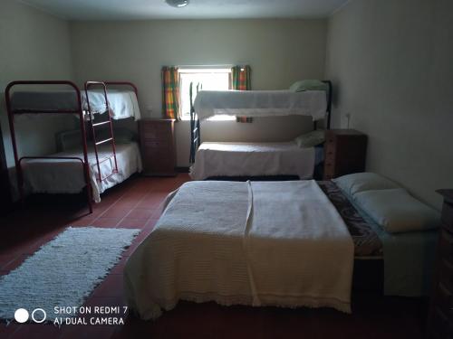 a bedroom with two beds and a window at Stone Farm Hostel in Felgueiras