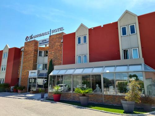 een rij gebouwen met planten ervoor bij The Originals City Hôtel Marseille Aéroport in Vitrolles