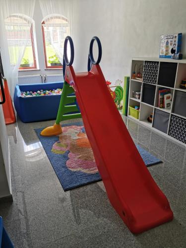 a red slide in a play room with a playground at Zamoček in Matiašovce