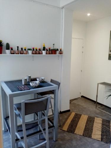 une table et deux chaises dans une pièce avec une table dans l'établissement Grand T3 Montpellier Comedie Gare Saint Roch, à Montpellier