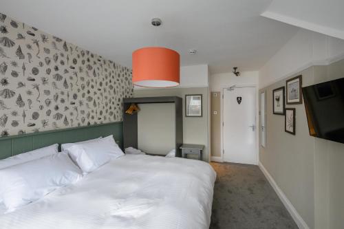 sypialnia z dużym białym łóżkiem i telewizorem w obiekcie Balfour Arms w mieście Sidmouth