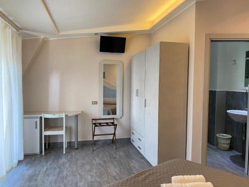 een slaapkamer met een bureau en een tafel met een spiegel bij Hotel Moderno - Bed & Breakfast in Cervia