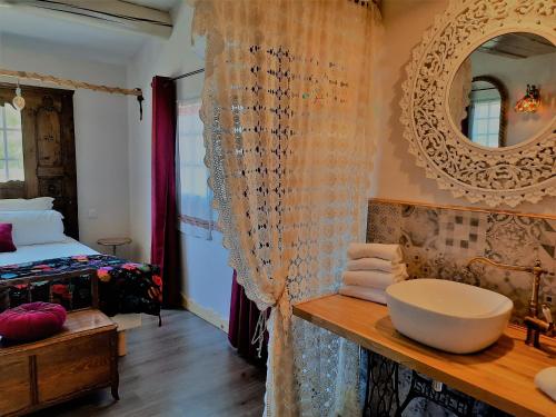 a bathroom with a sink and a bed and a mirror at Mas Fandelou in Saintes-Maries-de-la-Mer