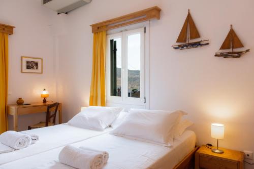two beds in a room with a window at Margado in Kamares