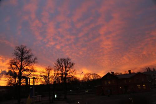 a sunset with trees in front of a building at Vingåker Hotell in Vingåker