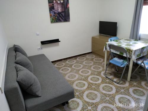 una sala de estar con un sofá y una mesa en loft turistic, en San Vicente dels Horts