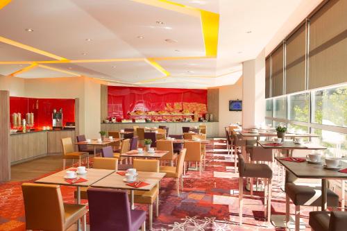 a restaurant with tables and chairs and a counter at Oceania Clermont Ferrand in Clermont-Ferrand