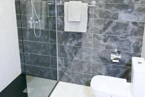 a bathroom with a shower and a toilet at Baleal poolfront apartment in Baleal