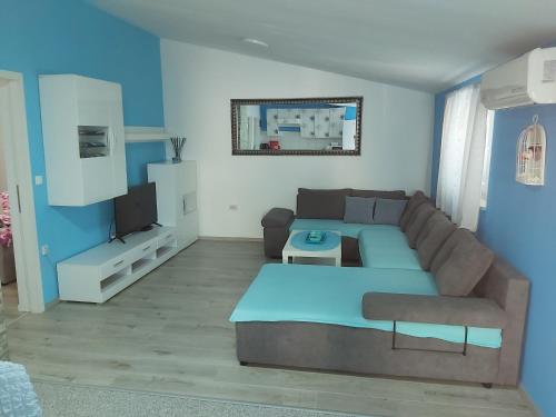 a living room with a couch and a tv at Apartman Ana in Štinjan