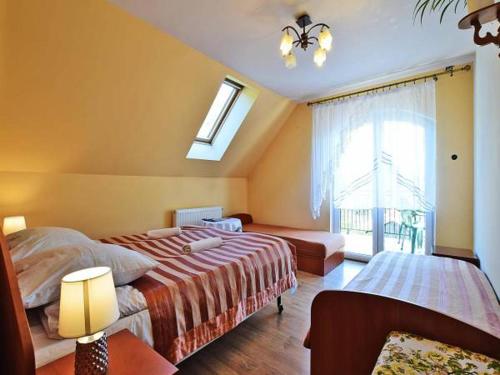 1 dormitorio con 2 camas y ventana en Agroturystyka przy lesie, en Ludwin