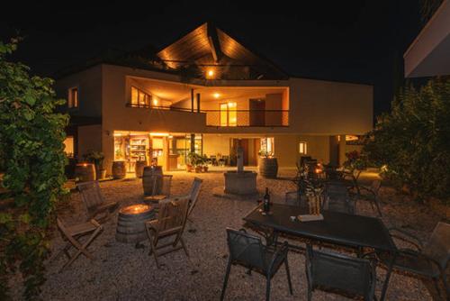 a house with chairs and tables in front of it at Biobauernhof St. Quirinus in Caldaro