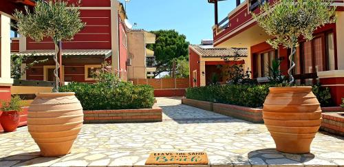 two large vases sitting on a sidewalk in front of a building at Medusa's Villas in Acharavi