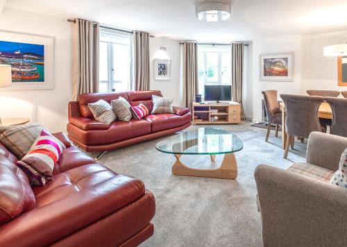 a living room with leather furniture and a glass table at The Malt Kiln Apartment Edinburgh Old Town 3 Bedroom in Edinburgh