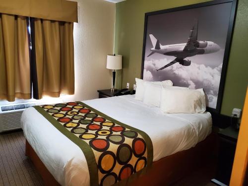 a hotel room with a bed with a picture of a plane at Super 8 by Wyndham Edmonton International Airport in Leduc
