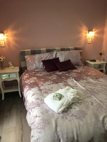 a bed with a white towel on top of it at Ben Lomond Cottage in Gartocharn