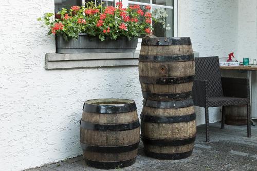 two wooden barrels sitting next to a table with flowers at Landgasthof Hieren Mühle in Ney