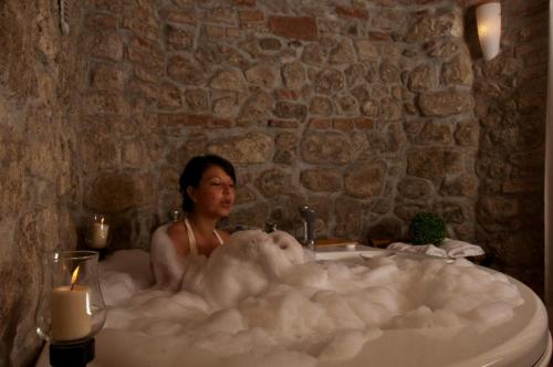 a man sitting in a bath tub filled with foam at Hotel Residence Sant'Uberto in Roccastrada