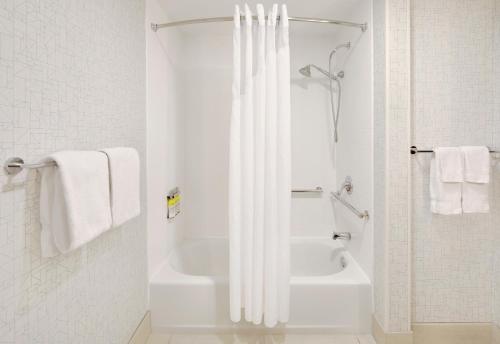 Baño blanco con bañera y cortina de ducha en Holiday Inn Express & Suites Tilton, an IHG Hotel, en Tilton
