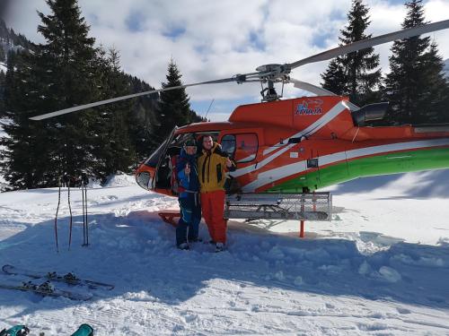 a man is standing in front of a helicopter at Ski&Bike Nassfeld Apartments in Hermagor