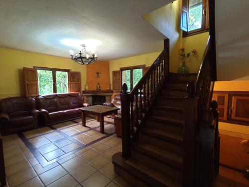 a living room with a staircase and a couch at Casa el Viñadal in Arguebanes