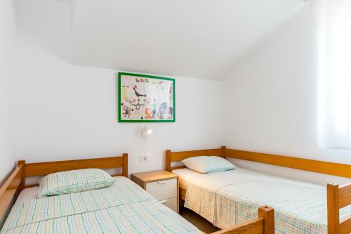 a bedroom with two beds and a picture on the wall at Jadrija Bay in Šibenik