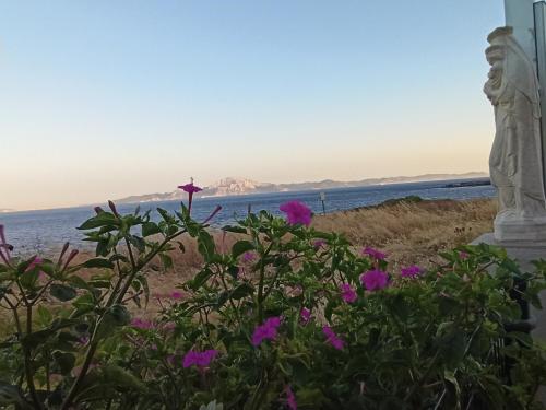 a statue next to the water with flowers at Punta Carnero Hostal in Algeciras