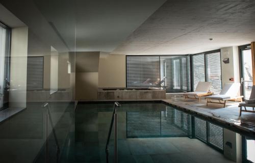a house with a swimming pool and a living room at Agritur Renetta in Tassullo