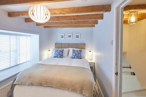 a bedroom with a large bed with blue pillows at Host & Stay - Amber Cottage in Whitby