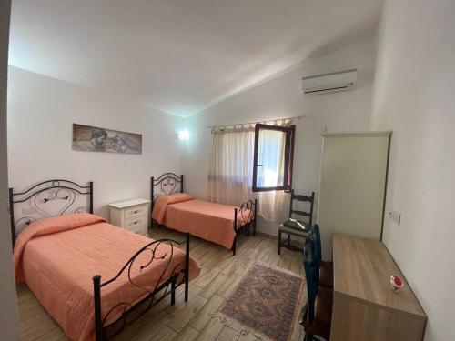 a bedroom with two beds and a table and a desk at Stazzo Galeone in Casagliana