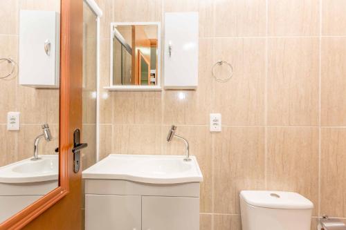 a bathroom with a sink and a toilet and a mirror at Pousada F7 in Campinas