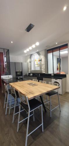 une cuisine avec une grande table et des chaises en bois dans l'établissement galerie Angle3, à Quimper