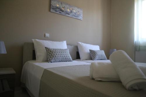 a bedroom with two beds with white sheets and pillows at Kleanthi's House in Chania Town