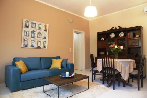 ein Wohnzimmer mit einem blauen Sofa und einem Tisch in der Unterkunft Kleanthi's House in Chania