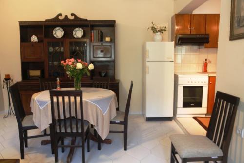 a kitchen with a table and a white refrigerator at Kleanthi's House in Chania Town