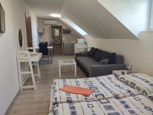a room with a bed and a living room with a couch at Ubytovanie LISKA in Radava