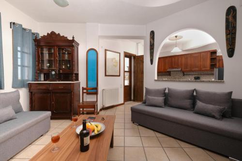 un soggiorno con 2 divani e un tavolo di Private Villa Evgenia with swimming pool a Perissa