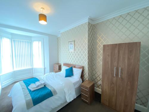 a bedroom with a bed and a cabinet in it at Warwick Street Professional Lets in Newcastle upon Tyne
