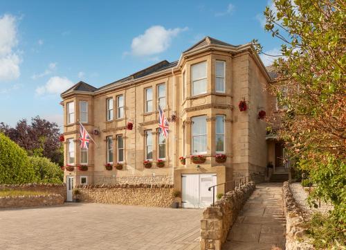 a large building with two flags in front of it at Bathen House Boutique Hotel in Bath