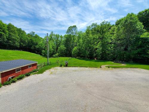 an empty parking lot next to a red building at The Barn Inn Bed and Breakfast in Millersburg