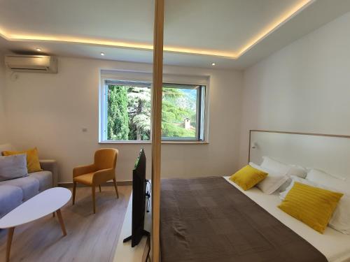 Un dormitorio con una cama y una mesa y una ventana. en Viola lux apartments, en Kotor
