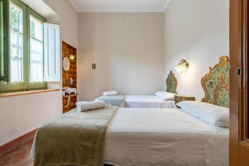 two beds in a room with white walls and windows at Mas Barbat in Lilla
