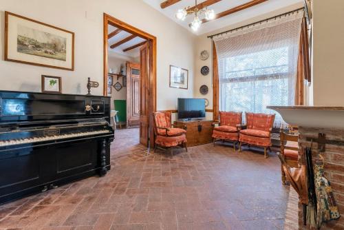 a living room with a piano and chairs at Mas Barbat in Lilla