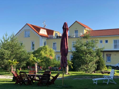 a table with a umbrella and chairs in front of a building at Holiday Centrum in Žatec