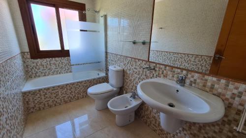 y baño con lavamanos, aseo y lavamanos. en Apartamentos Coral Do Mar III en Montalvo