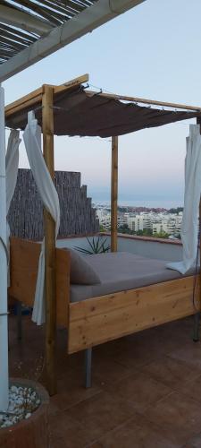a canopy bed on top of a roof at Atico Nacho in Torremolinos