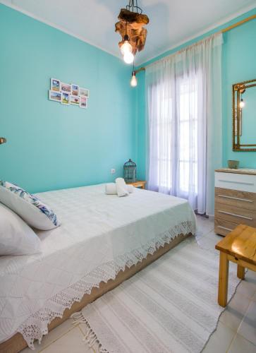 a bedroom with a large bed with blue walls at Olive Cottage in Astris