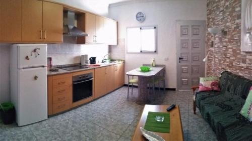 eine Küche mit einem Sofa, einem Kühlschrank und einem Tisch in der Unterkunft Casa Mari Playa De Mogan in Puerto de Mogán