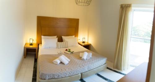 - une chambre avec un grand lit et 2 oreillers dans l'établissement Nicky Apartments Chania, à La Canée