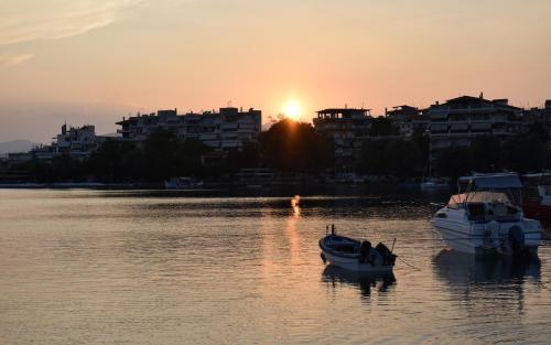 two boats sitting in the water at sunset at Philoxenia Hotel in Lefkandi Chalkidas